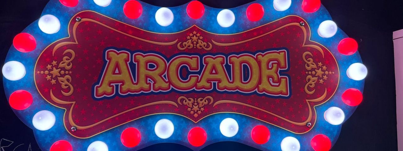 Arcade backboard above LED-lit DJ booth