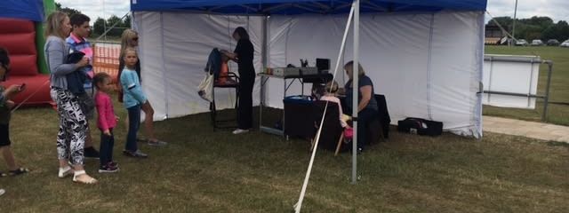 Blue gazebo set up at outdoor family funday