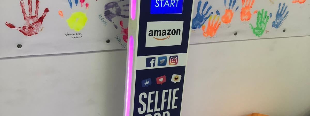 Amazon-branded selfie pod beside a handprint wall