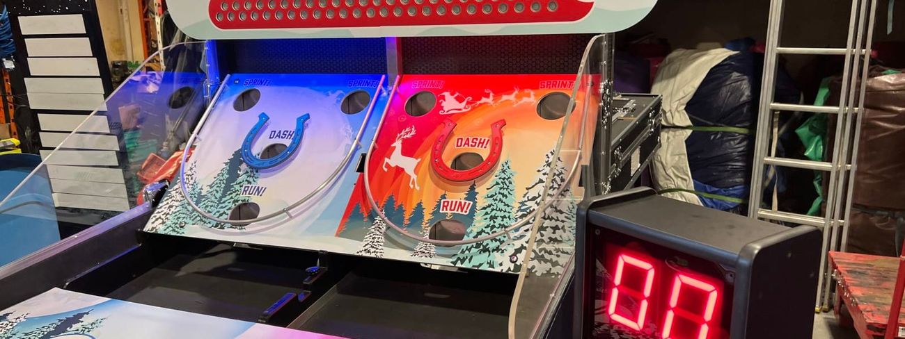 Large red LED countdown timer on a stand beside a Christmas-themed bounce-a-ball game
