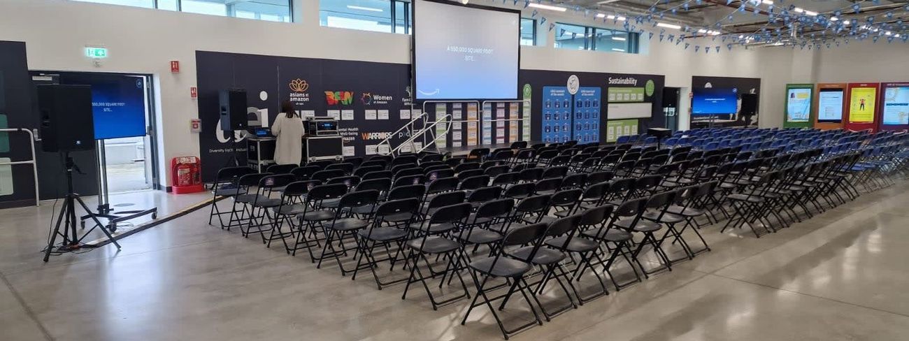 Black foldable chairs in rows at an event venue