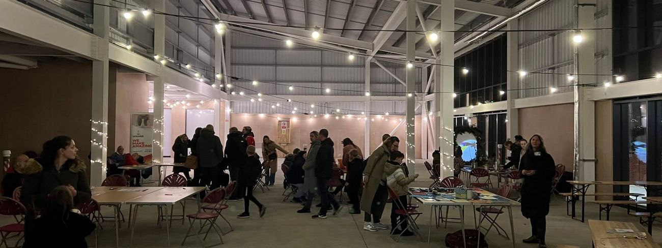 Indoor warehouse event with festoon-draped trestle tables