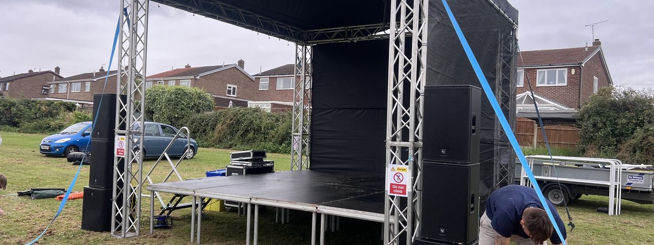4x4m event stage build with truss, PA speakers and lighting rigged outdoors