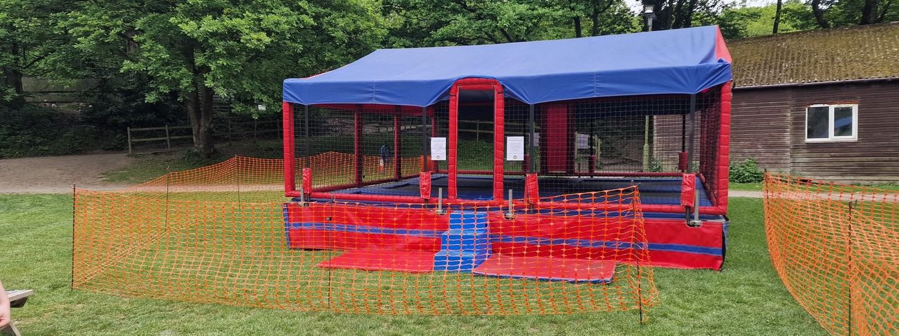 Six-bed bungee trampoline set up outdoors with safety harnesses