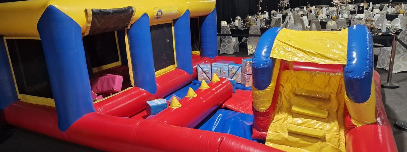 Giant inflatable bouncy castle obstacle course set up at an outdoor event