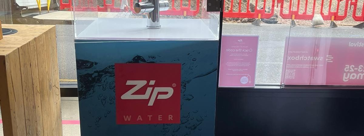 Crack the Code acrylic safe on a lit branded plinth