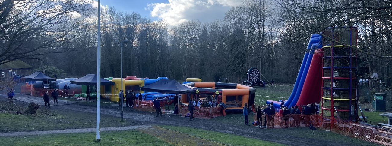 Outdoor event overview with giant helter-skelter slide and inflatable bungee run
