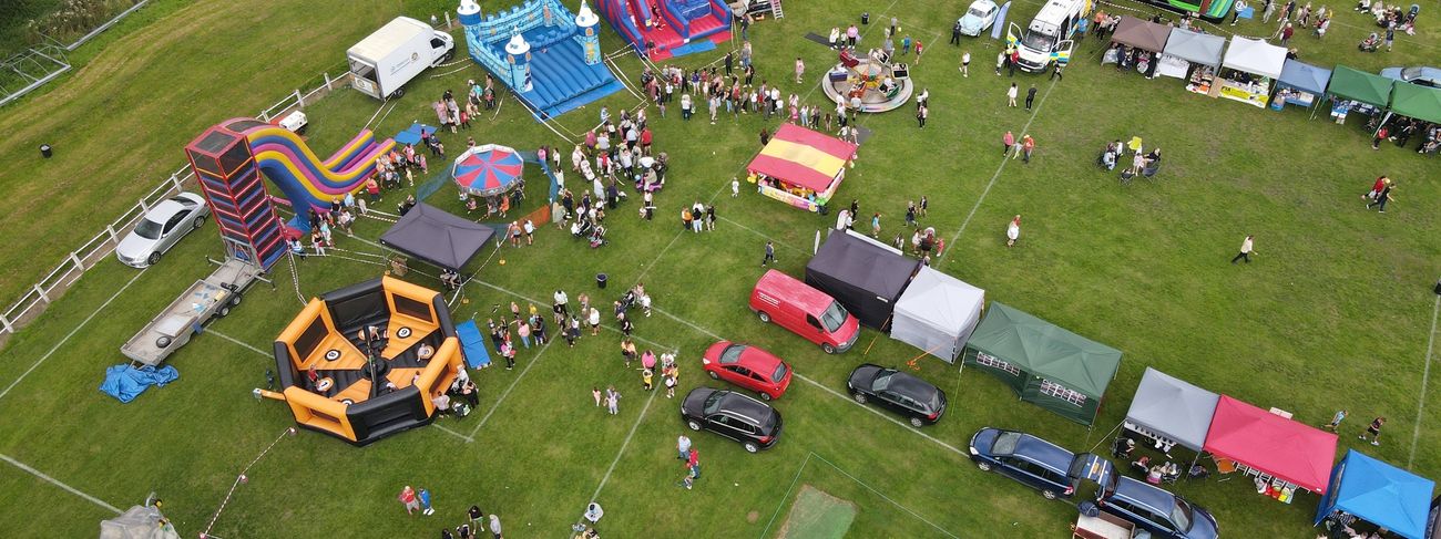Aerial overview of a large arena event packed with branded stalls and games