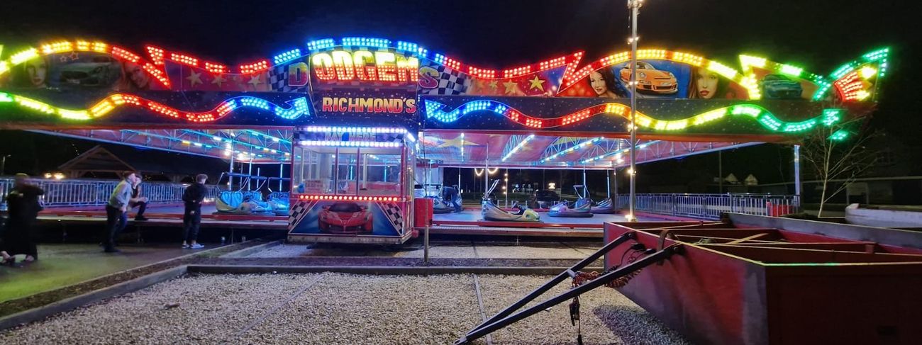 Funfair dodgems / bumper cars illuminated at night with full lighting rig