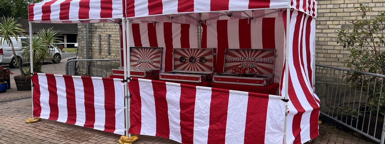 Twin marquee tents lined with carnival fun fair stalls at an outdoor event