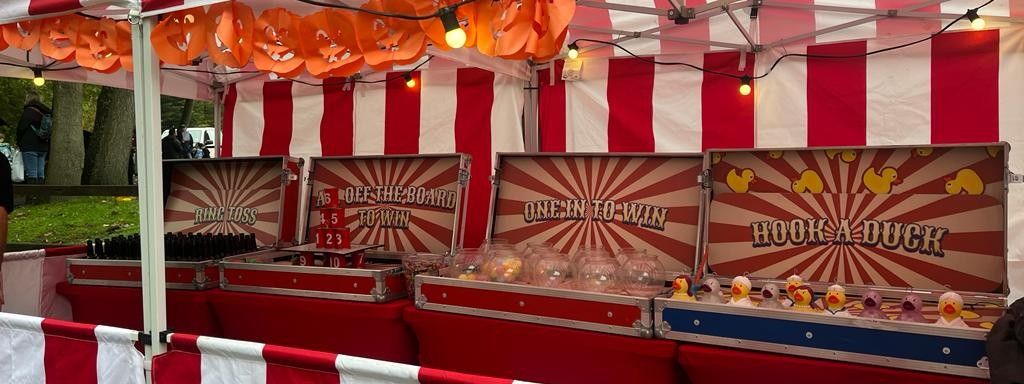 Halloween-themed carnival fun fair stalls dressed with carved pumpkins and autumn decorations