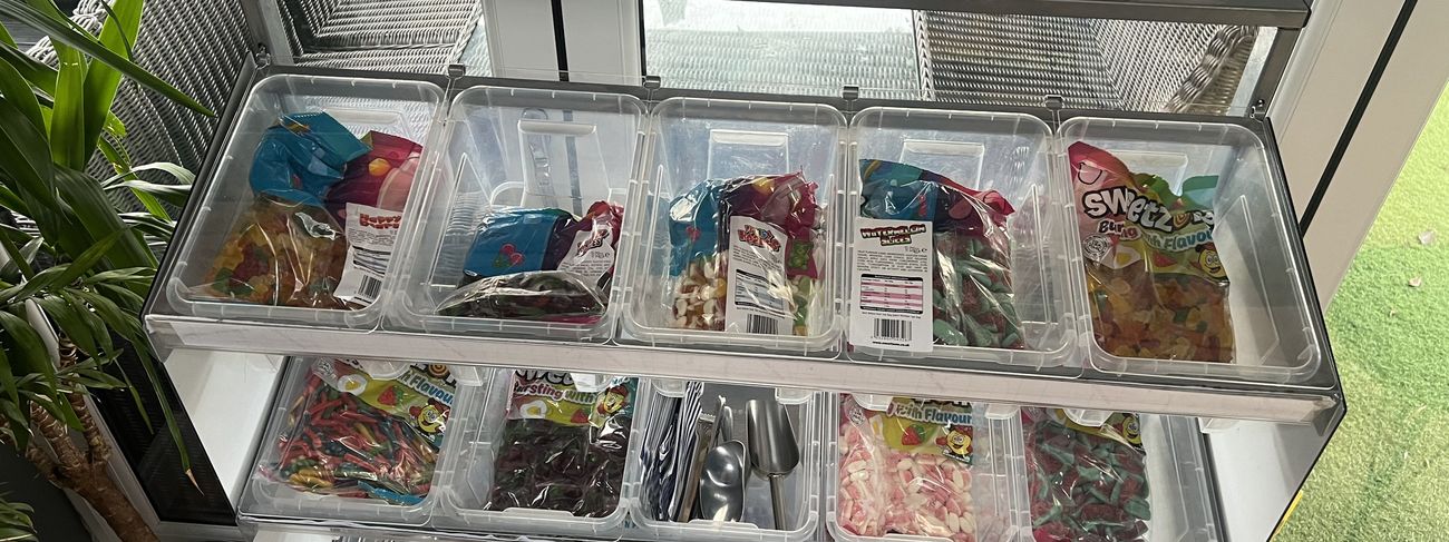 Pick 'N' Mix Sweetie Stand with branded pink banner and rows of glass sweet jars