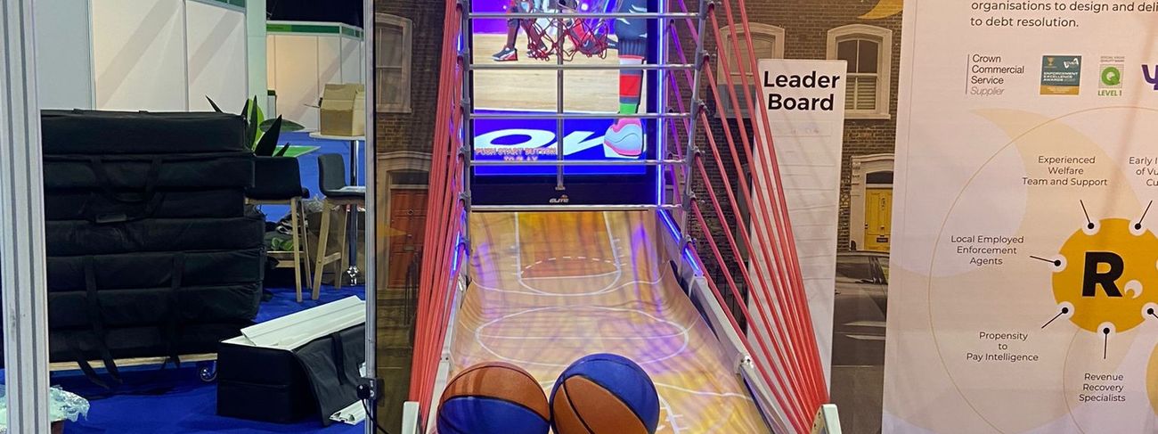 Visitors playing an interactive basketball game on a branded exhibition stand