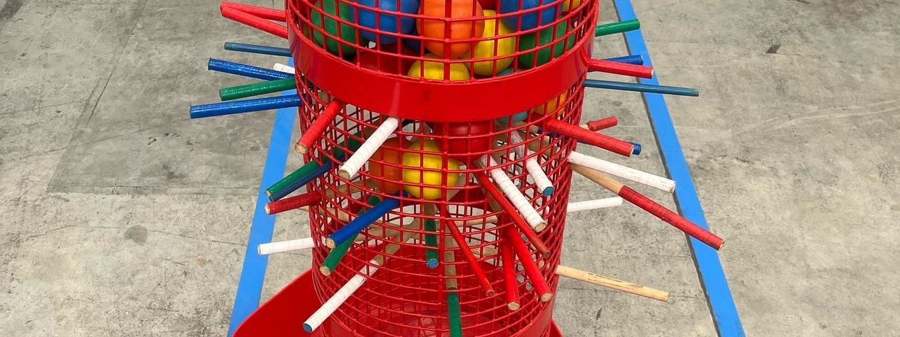 Mega Kerplunk red mesh tower filled with coloured balls and rods in a warehouse