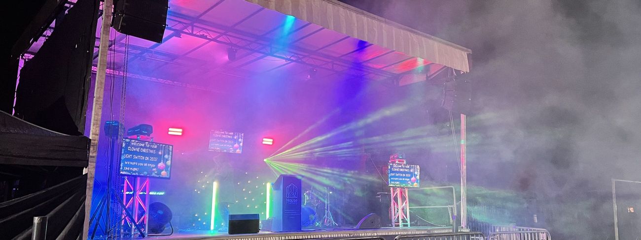 Mobile trailer stage with full PA, lighting and a green laser show at night