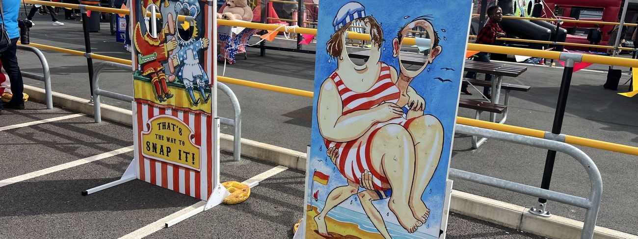 Punch and Judy photo cut-out board next to a beach-themed board at an outdoor Amazon event