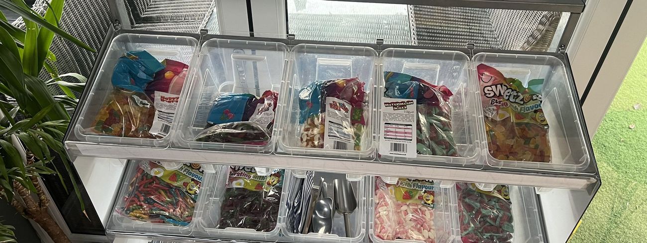 Pick 'N' Mix Sweetie Stand with branded pink banner and rows of glass sweet jars