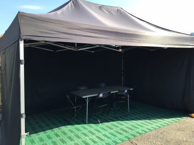 Black 3x4.5m gazebo with green carpet, foldable table and chairs inside