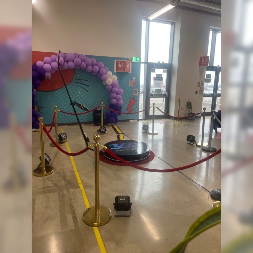 360 photo booth platform and camera arm with a colourful printed backdrop
