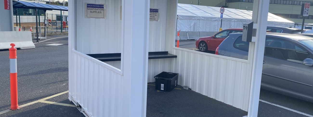 White 8x8ft open-fronted steel smoking shelter set up in a car park