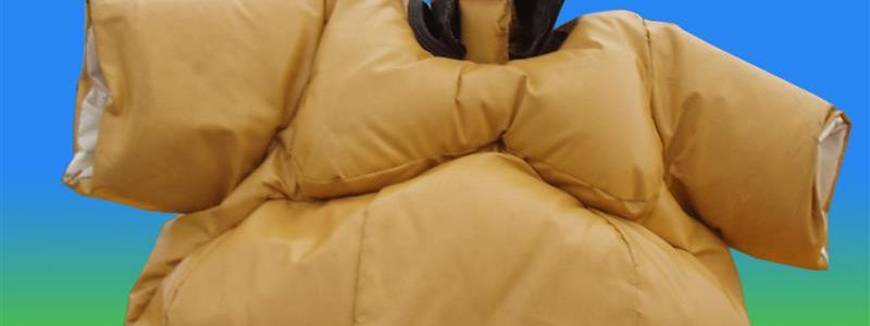 Adult sumo suit with a black headpiece and red belt, standing on the blue and yellow crash mats