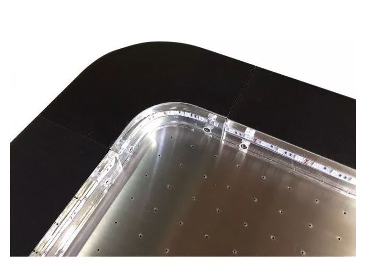 Close-up of the air hockey table corner showing perforated playing surface and LED strip