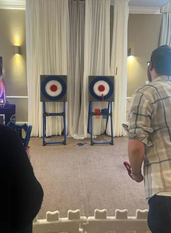 Soft-axe throwing target boards set up at a venue with axes thrown into the right-hand bullseye