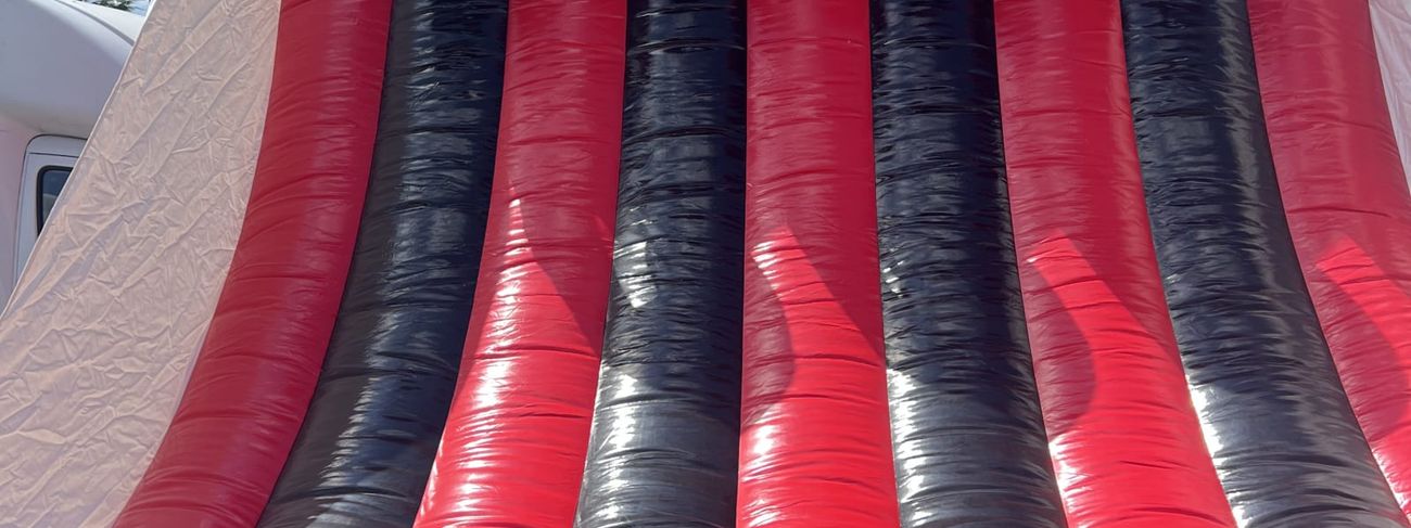 Tall red and black inflatable basketball game with four hoops numbered one to four across the top