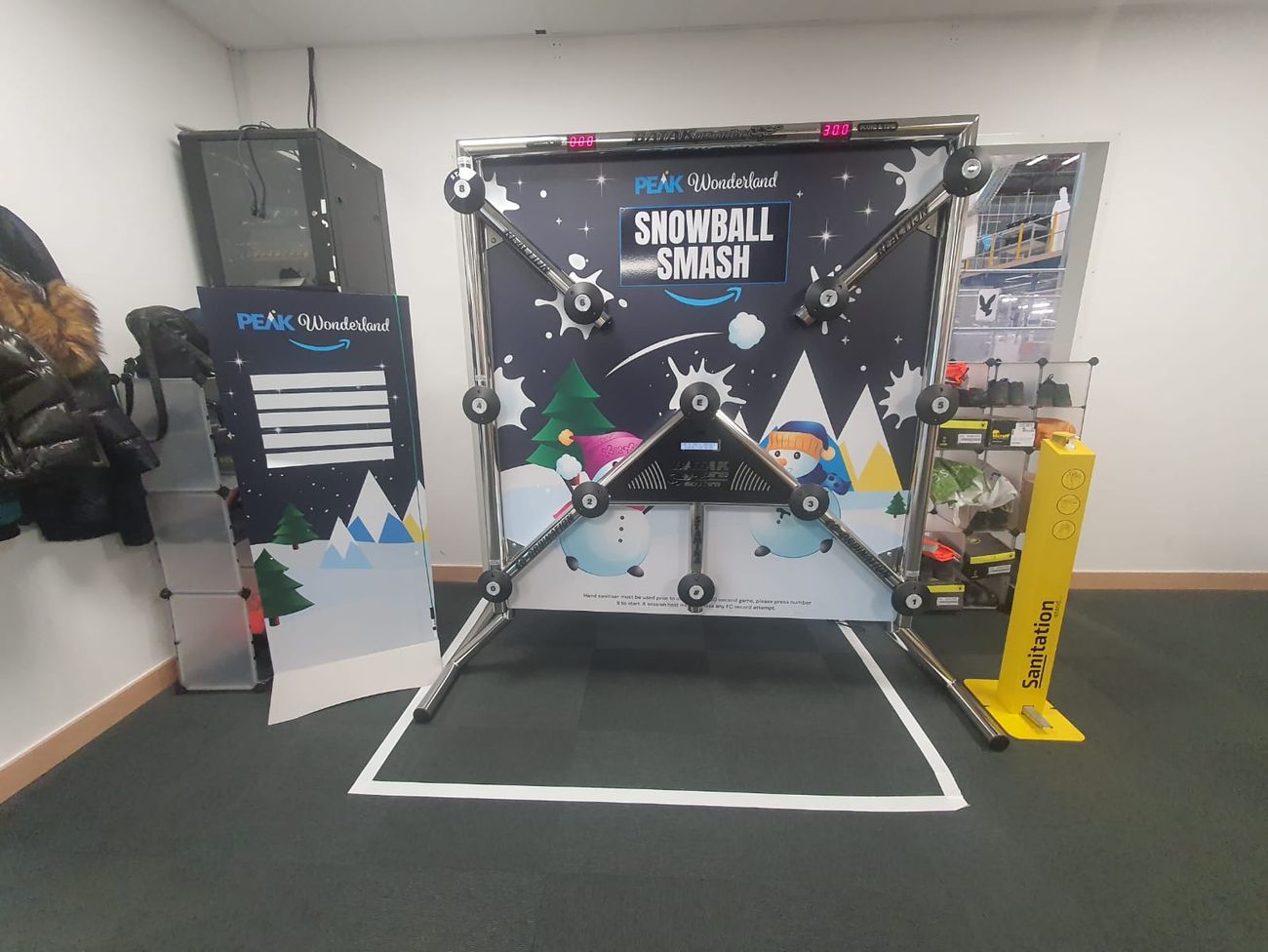 Snowball Smash reaction game in a hire warehouse beside a leaderboard and sanitation stand