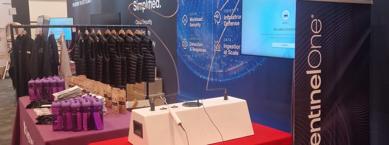 Beat the Buzzer tabletop buzz wire unit on a red-draped table at the SentinelOne cybersecurity exhibition stand