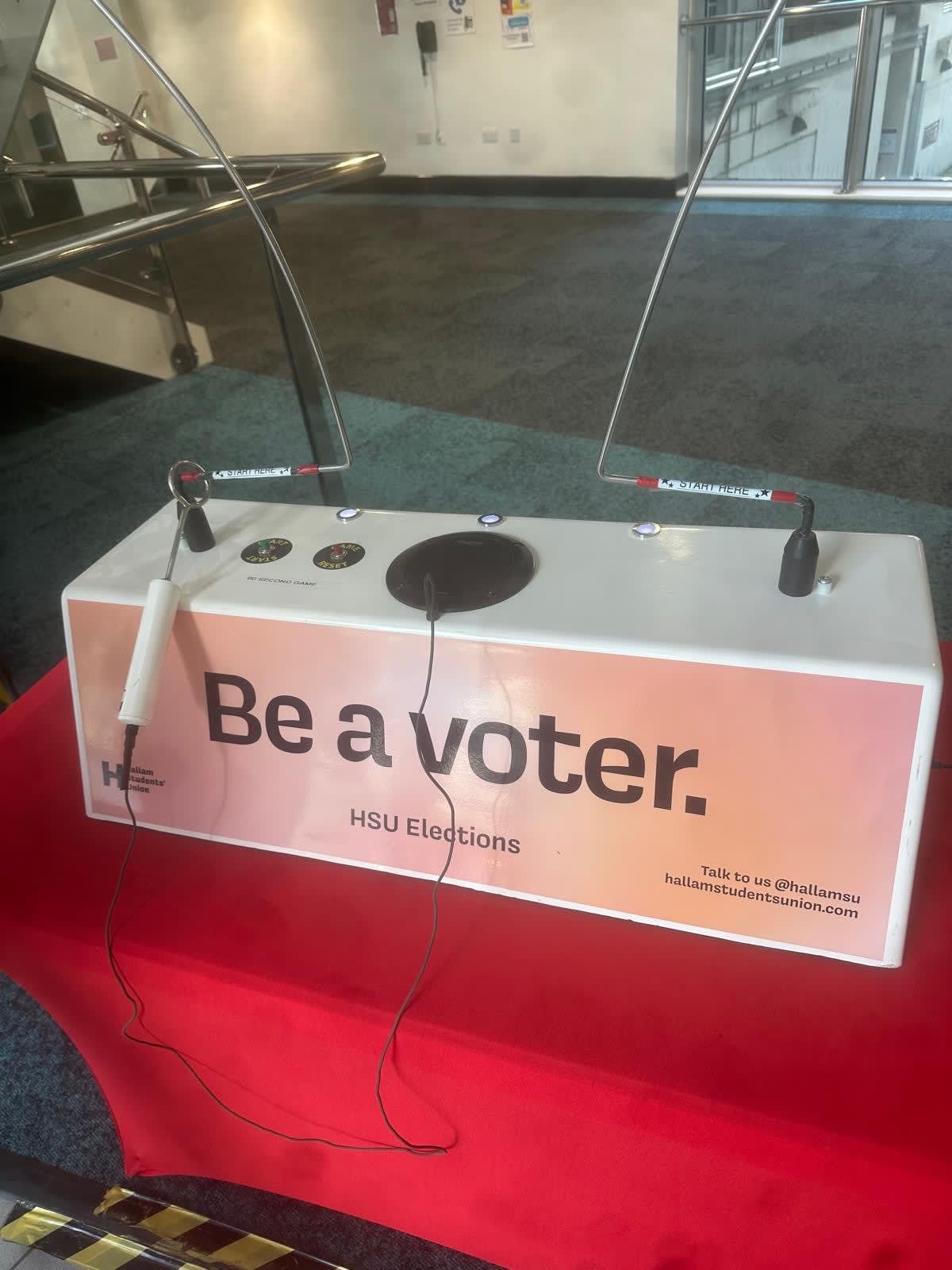 Close-up of the Beat the Buzzer console with two wand handles and Hallam Students Union "Be a voter" branding