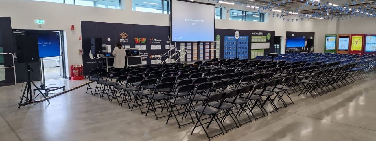 Rows of black folding chairs set up for a corporate presentation