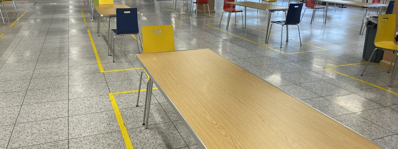 Rows of Gopak Economy folding tables with Durham Oak tops set up in an Amazon staff canteen with colourful chairs