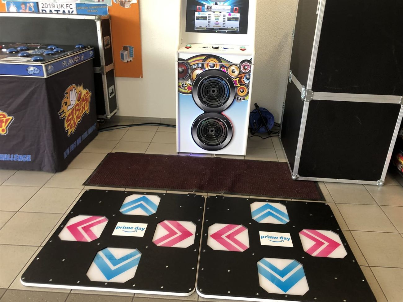 Two hard arrow pads with Amazon Prime Day centre branding in front of the dance machine cabinet