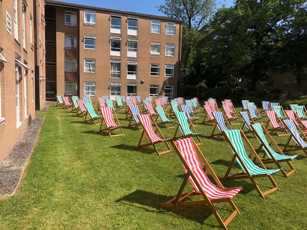 Striped deck chairs in neat rows on a campus lawn