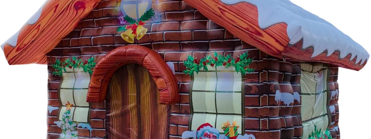 Inflatable Santa's grotto cottage with snow-capped roof, painted brick walls and Santa with reindeer