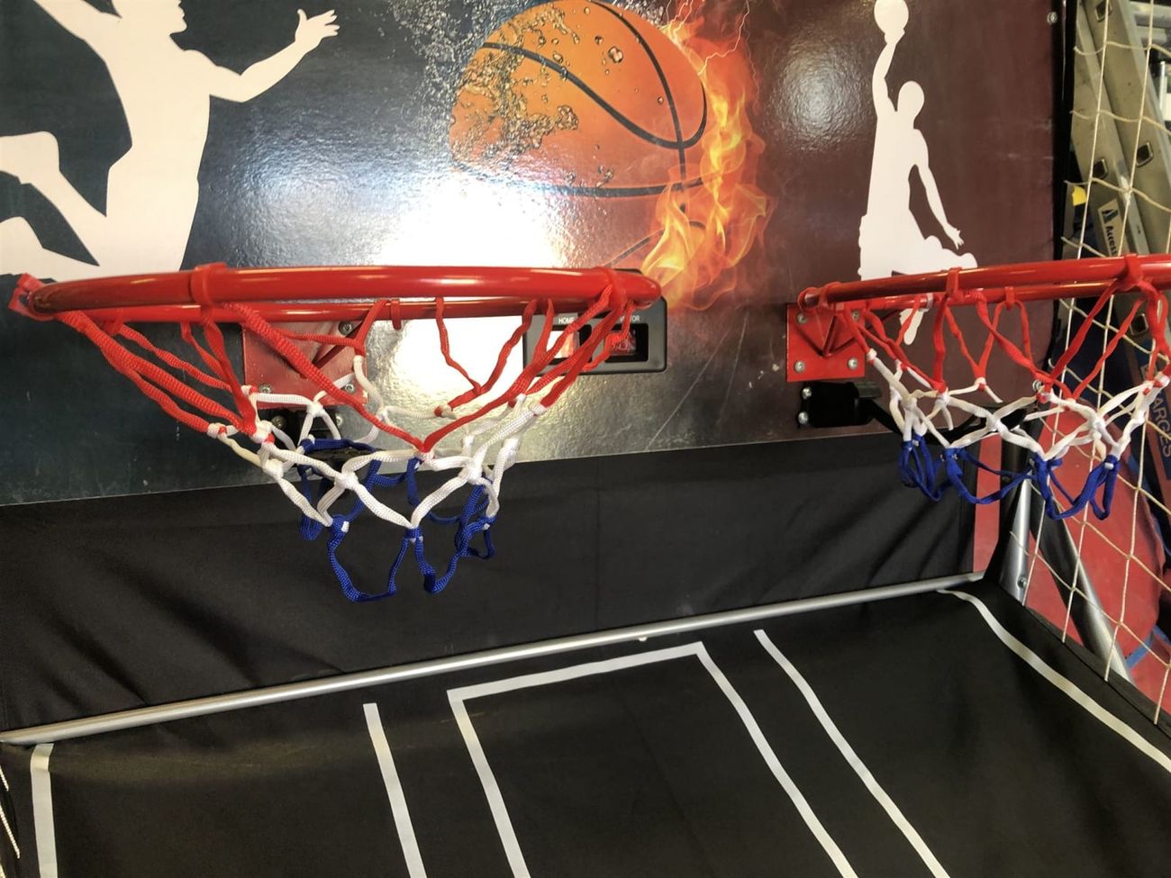 Close-up of twin red basketball rims with white and blue nets
