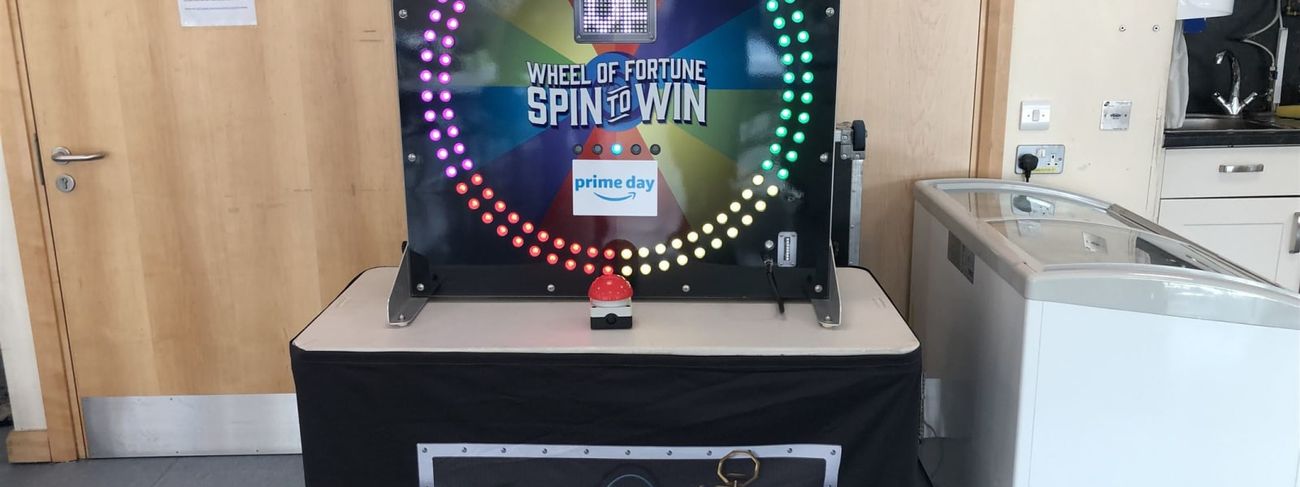 Electronic Wheel of Fortune panel in Amazon Prime Day Spin to Win branding, on a black skirted table