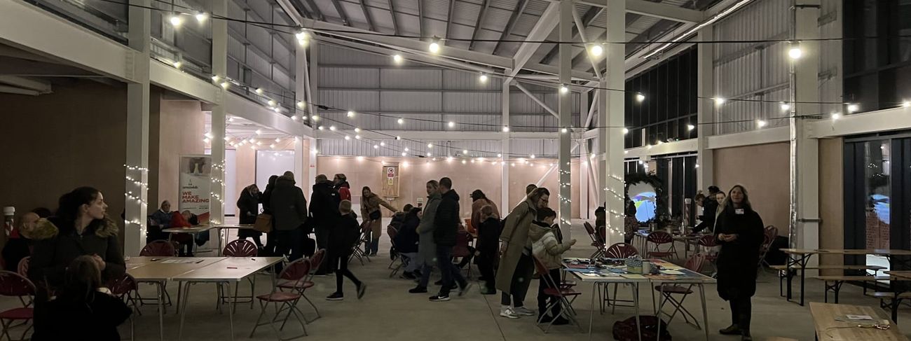 Indoor warehouse event with festoon-draped trestle tables