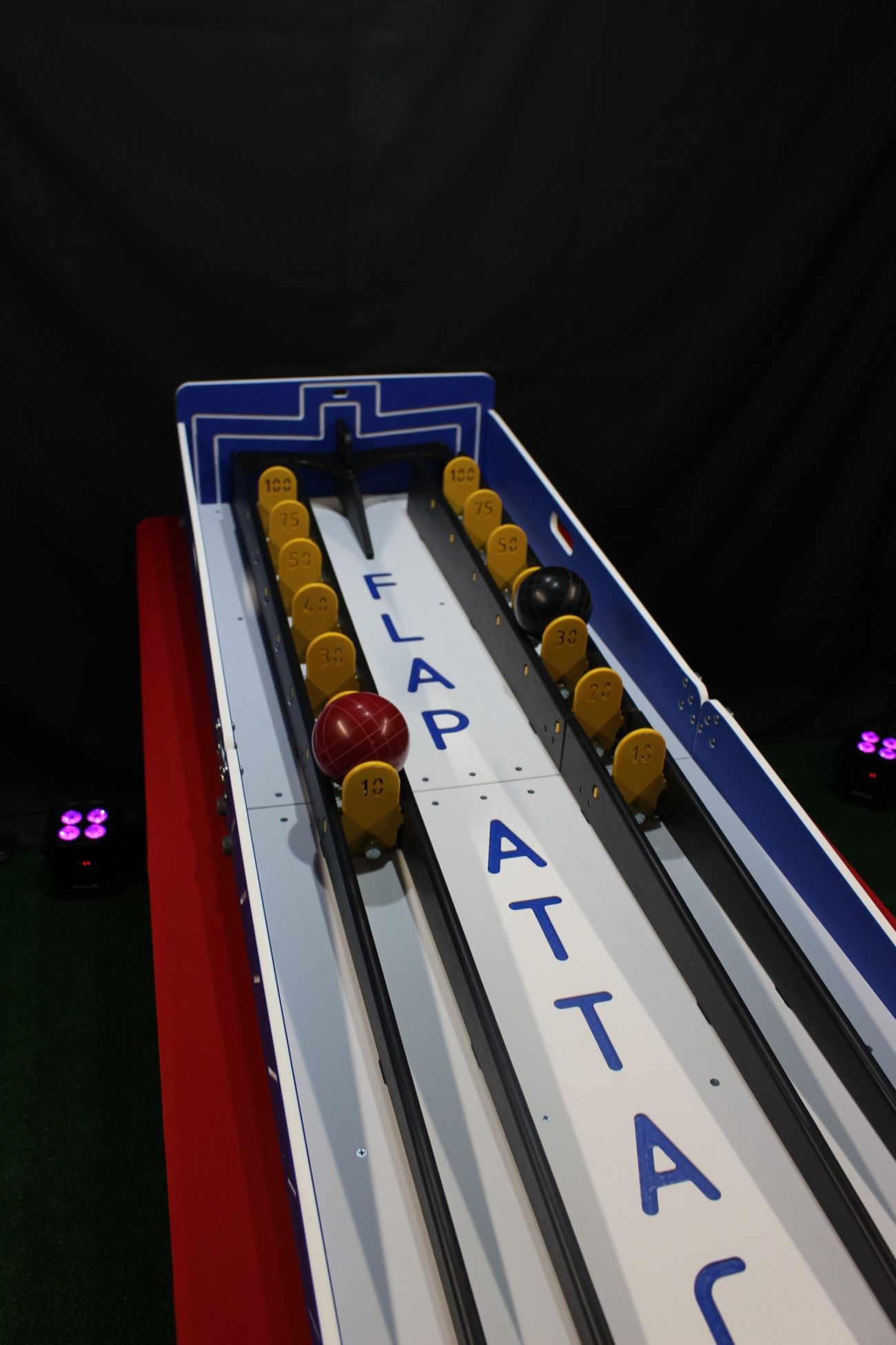 Red and black balls at different points on the two Flap Attack scoring lanes