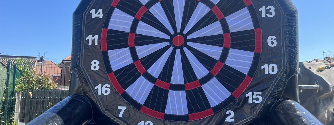 Giant inflatable football dartboard with velcro footballs stuck across the scoring rings
