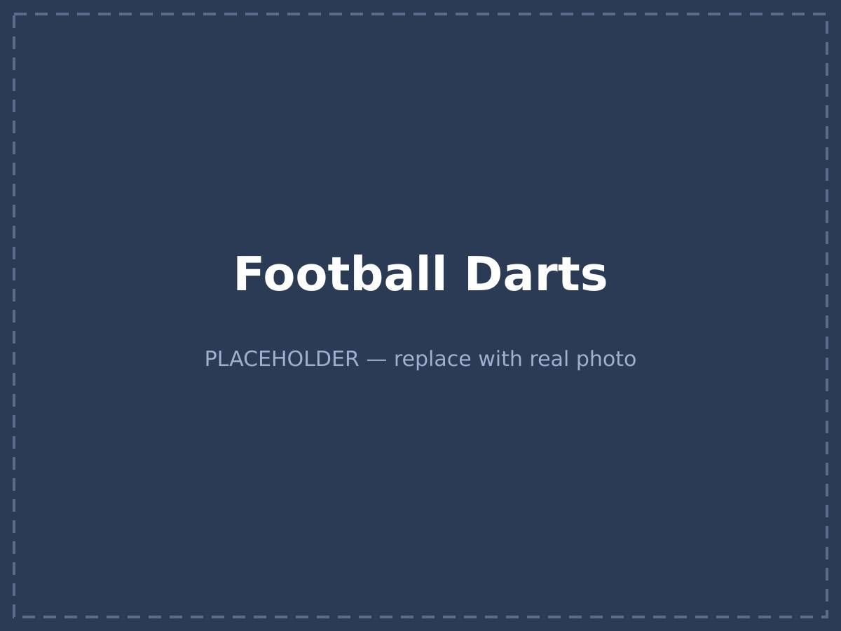 Player kicking a velcro football at a giant inflatable dartboard at an outdoor event