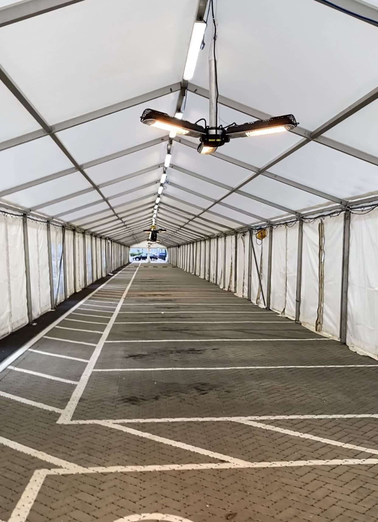 Infrared heaters hung at intervals down the frame of a long marquee