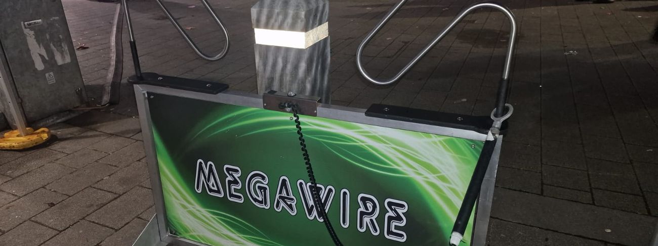 Green Megawire giant buzz wire game set up on a high street at night