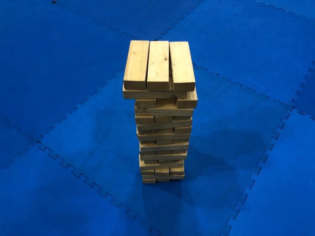 Wooden block tower on blue mat flooring