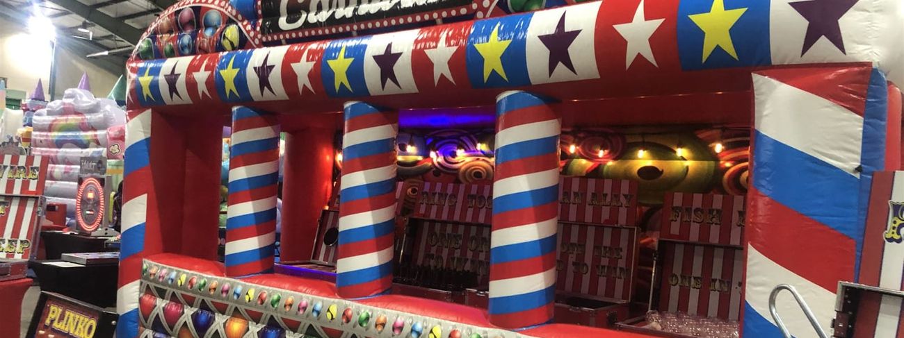 Grand Carnival inflatable fairground stall set up in a large exhibition hall