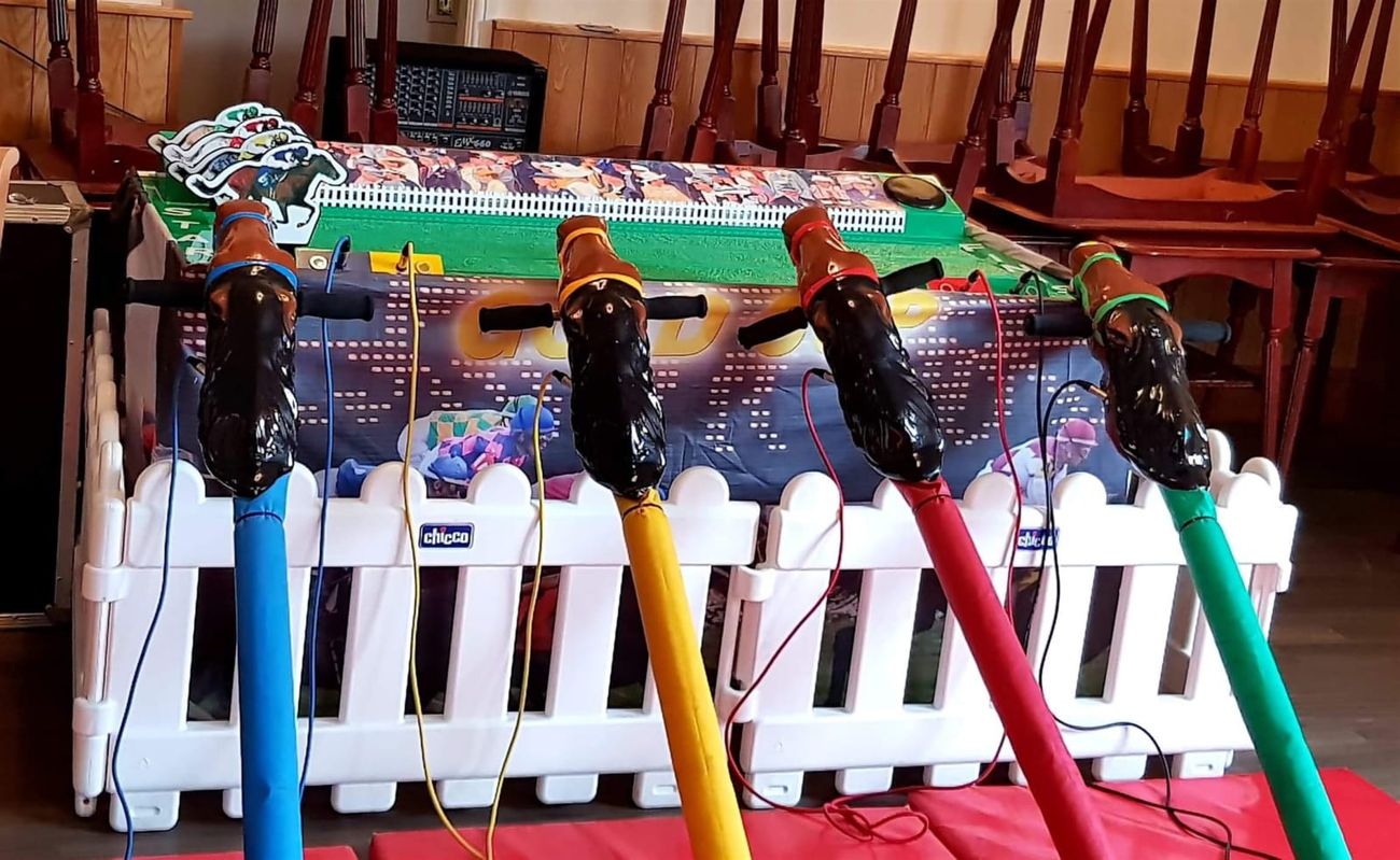 Four coloured hobby-horse poles lined up in front of the Gold Cup race-track unit ready to start