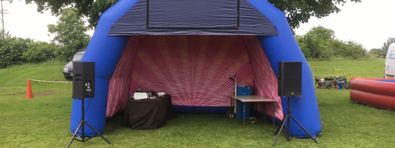 Canopy set up at outdoor event with PA speakers