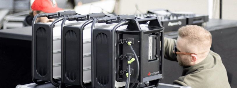 Three Instagrid ONE Max portable battery units cabled together through a LINK smart safety power distributor