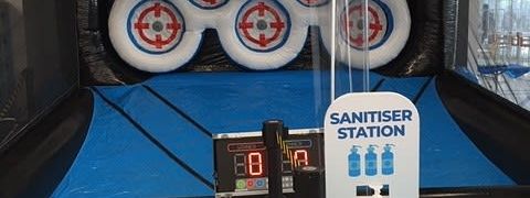 Indoor setup with scoreboard and sanitiser station